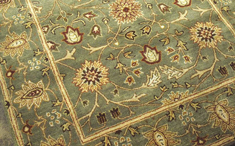 Green oriental rug with detailed floral border